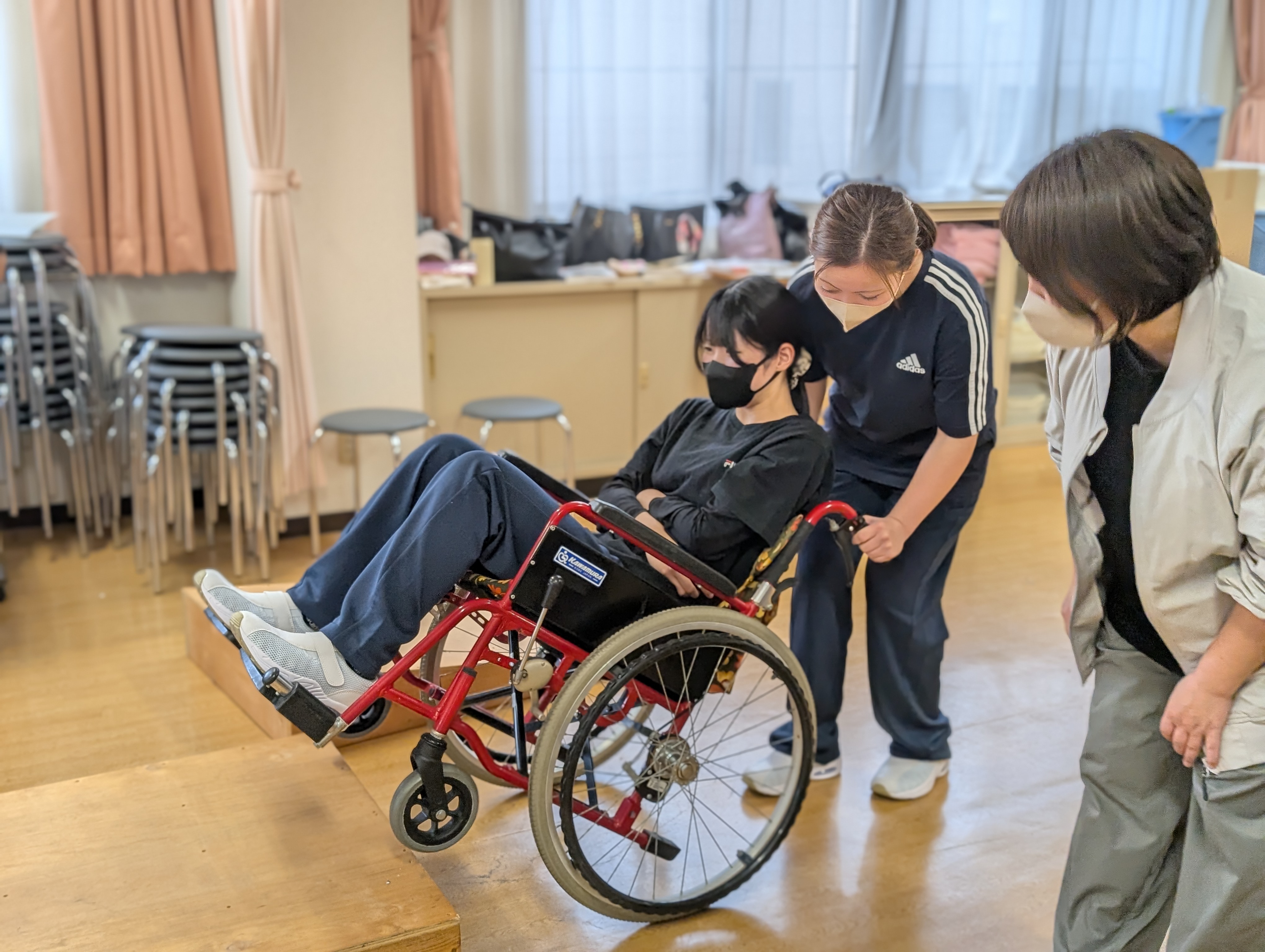 車いすを押す練習をする学生